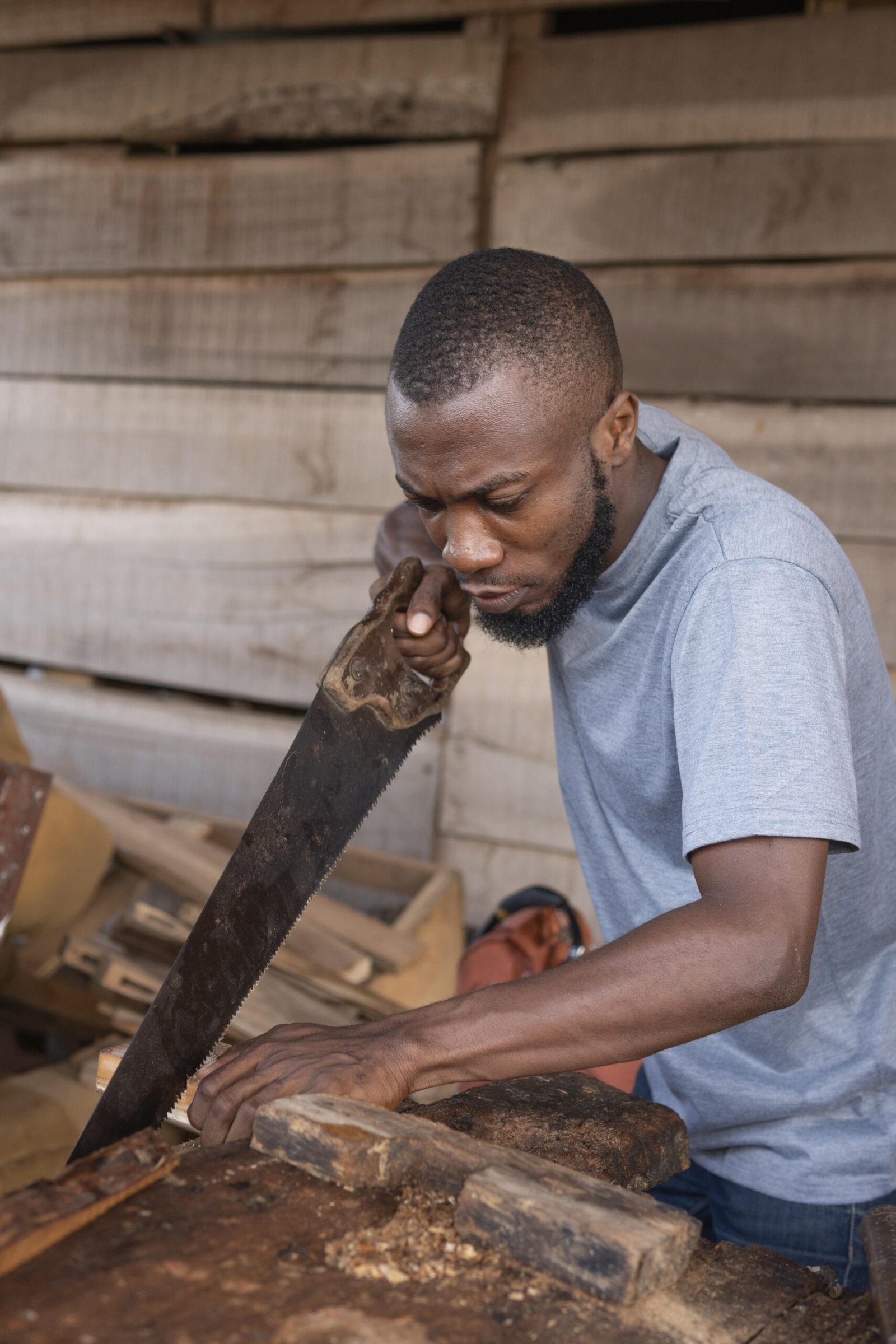 medium-shot-man-working-with-hand-saw (1)