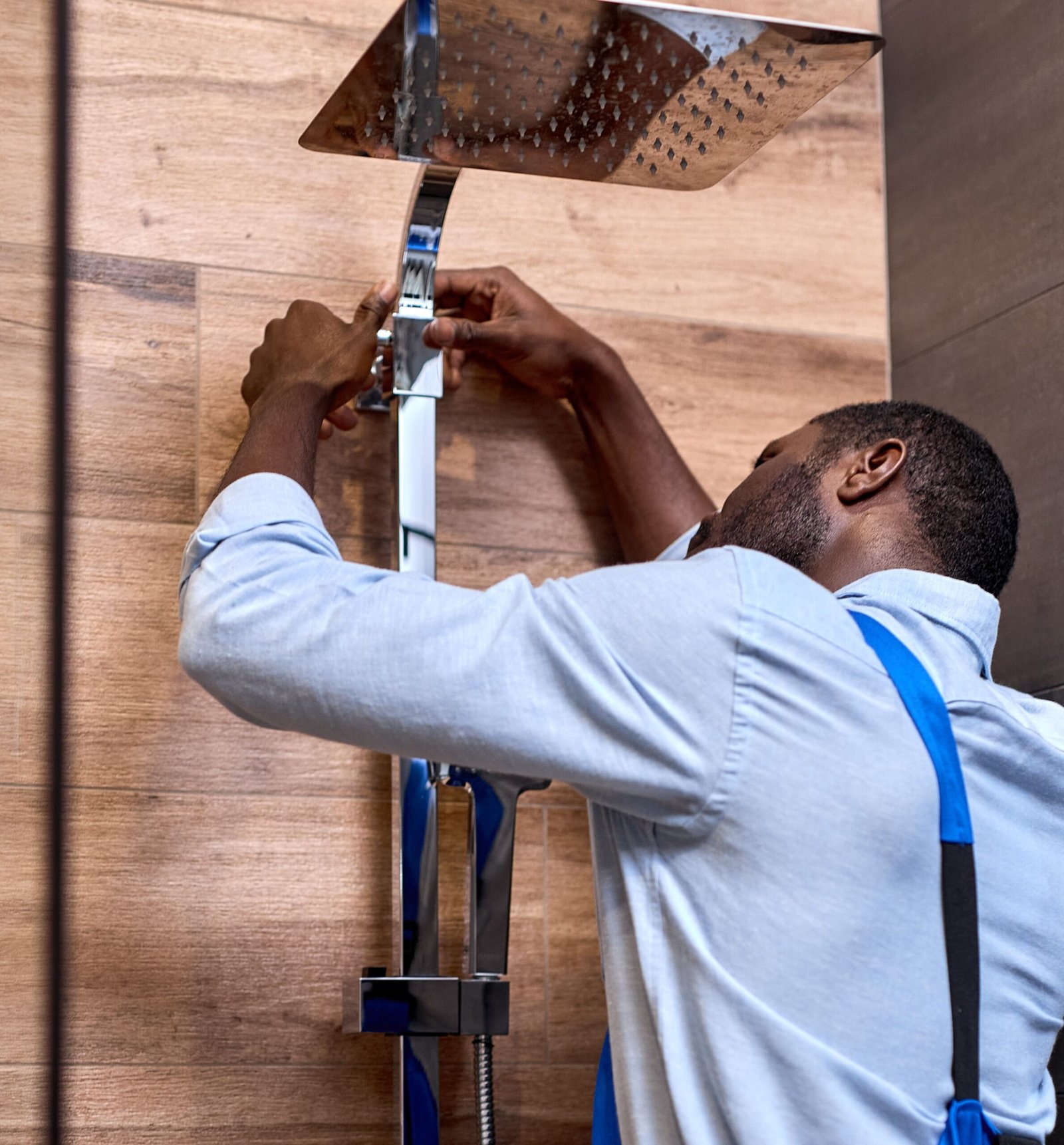 young-afro-american-plumber-man-repairing-fixing-faucet-shower-stall-side-view-portrait-black-professional-skilled-handyman-blue-overalls-repairing-shower-service-assemble-concept (1) (1)