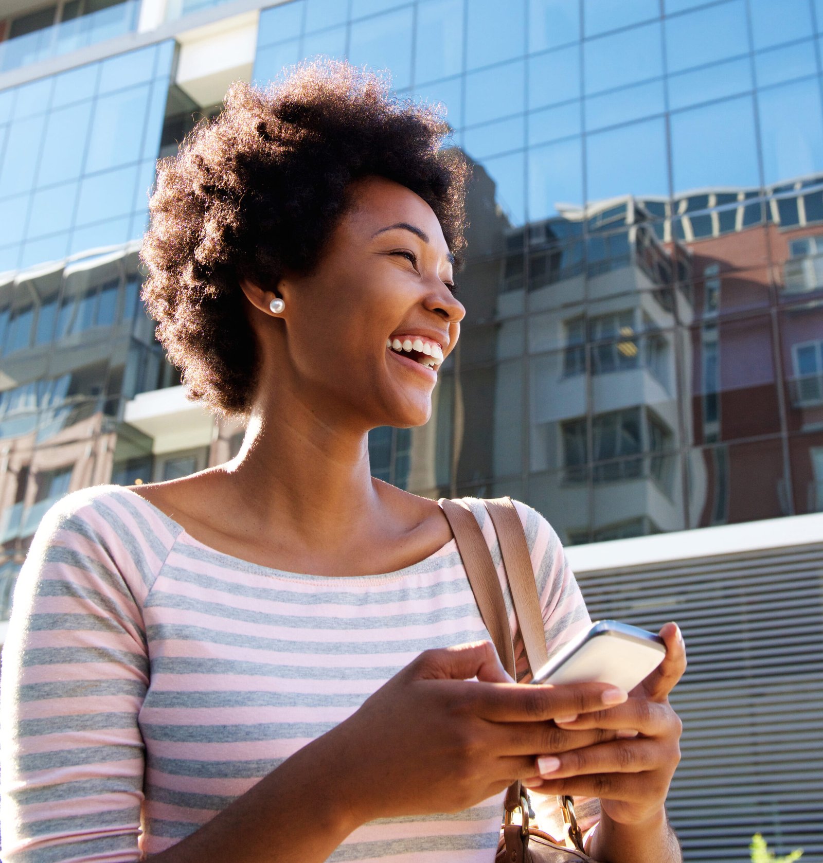 young-woman-laughing-with-cell-phone-purse-city (1) (1)